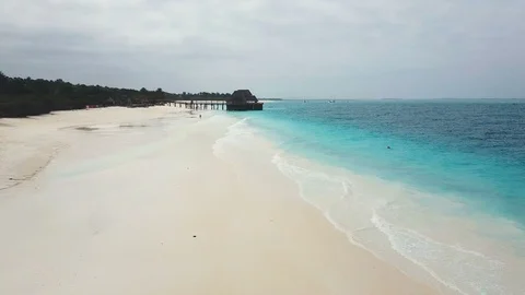 Flight over wide paradise beach with white sand and azure ocean on cloudy day Stock Footage 91802182