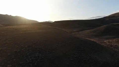 Flight over the wild hills to the sunset sun top view shooting using a Stock Footage 105028993