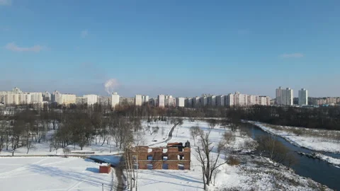 Flight over the winter city park. Snow covered earth. Town houses are visible Stock Footage 148093802