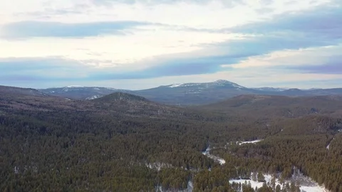 Flight over the winter forest and snow-capped mountains Stock Footage 125550630