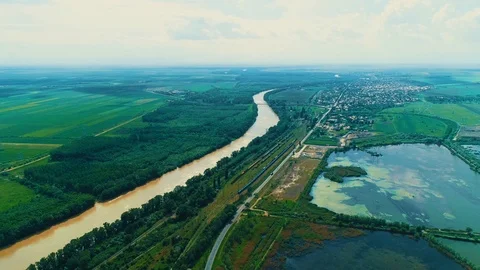 Flight over yellow dirty river after flood or so polluted near railroad in green Stock Footage 125480990