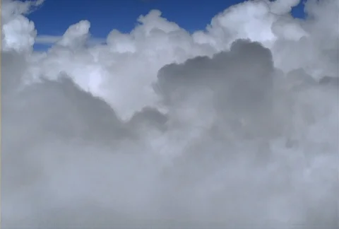 A flight passes over the tops of a mass of white and gray cumulus cloud Stock Footage 86881765