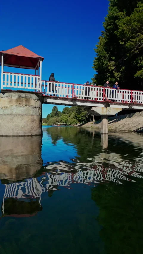 Flight past a red and white footbridge with several people standing at the Stock Footage 346015219