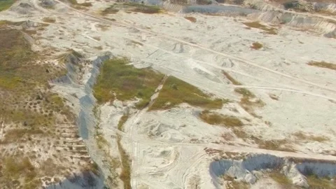 The flight of a quadrocopter over a grassy open pit Stock-Footage 120132430