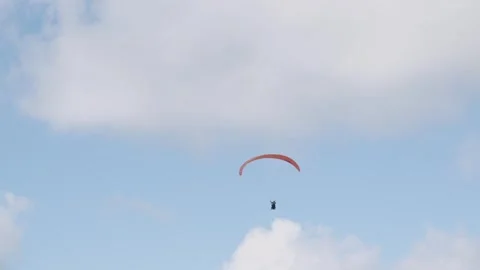 Flight of a red paraglider against the background of blue sky and clouds Stock Footage 320598277