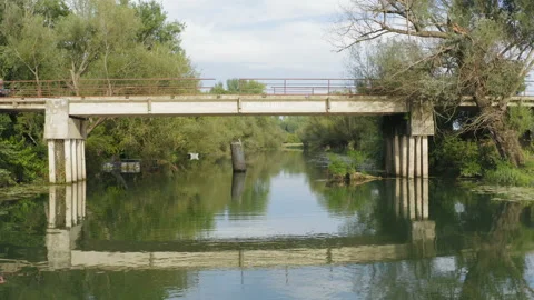 Flight by a rural bridge while two tractors are passing it Stock Footage 138530334