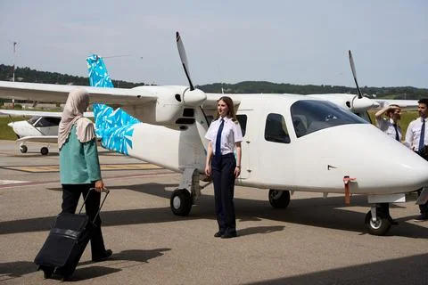 Flight school students and pilot posing with small airplane Stock Photos