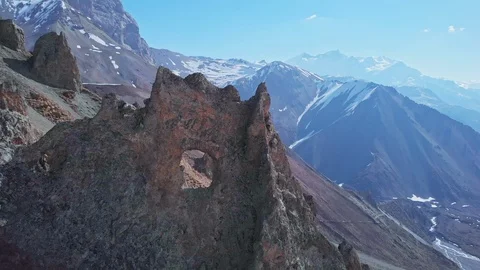 Flight from sharp crest cliff with hole, highland scree slope, blue sunny sky Stock Footage 124680603