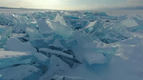 Flight shining ice hummocks, transparent ice blocks on frozen lake Arctic sunset Video stock 316453671