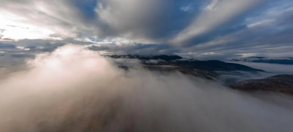 Flight through blue sky with clouds over mountain Stock Photos