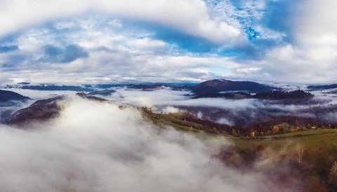 Flight through blue sky with clouds over mountain Stockfoto's