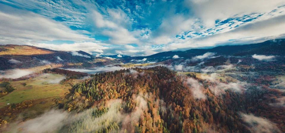 Flight through blue sky with clouds over mountain Stock Photos