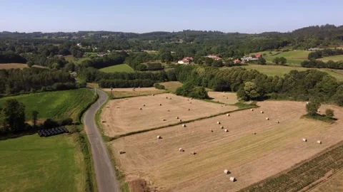 Flight Through Countryside Fields With Roll Hay Bale Near Idyllic Town Stock Footage 230449194