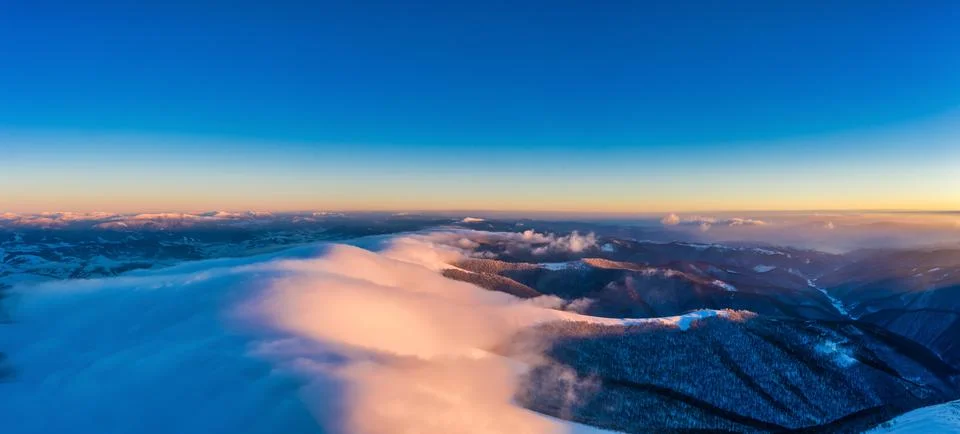 Flight through evening sky with clouds over mountain Foto stock