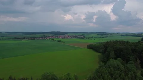 Flight through the forest and fields to a small village Stock Footage 155596748