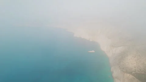 Flight through mist revealing views of Ionian Sea and rugged coastline Kefalonia Stock Footage 321559264