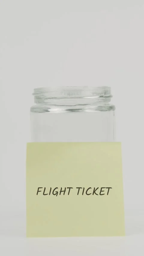 Flight ticket text or word on yellow sticky note attached to glass jar Stock Footage 311735016