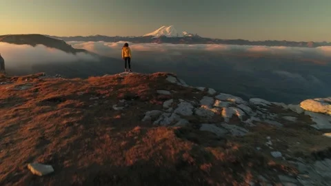Flight tourist people stands on edge. Elbrus mountain peaks fog clouds below 4k Video stock 153527770