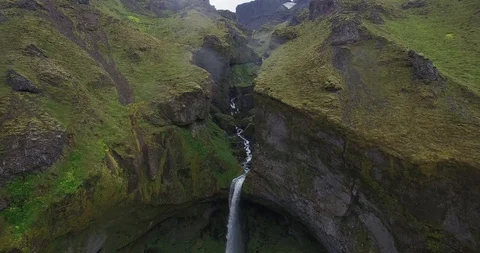 Flight towards waterfall between Icelandic mountain on a gllomy day Video stock 107542665