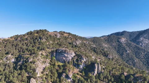 Flight traverses the rugged forest clad peaks behind Burunchel in Jaen province Vídeos de archivo 345129199