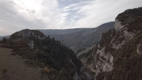 Flight trough cliffs, village on a cloudy sunrise 4k ungraded Stock Footage 105851152