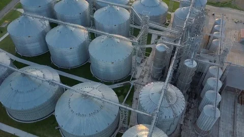 Flight under granaries and elevators or oil storage on sunset Stock Footage 76245211