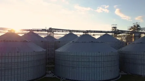 Flight under granaries and elevators or oil storage on sunset Stock Footage 76245227