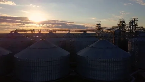 Flight under granaries and elevators or oil storage on sunset Stock Footage 76245245