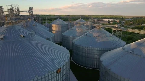 Flight under granaries and elevators or oil storage on sunset Stock Footage 76245248