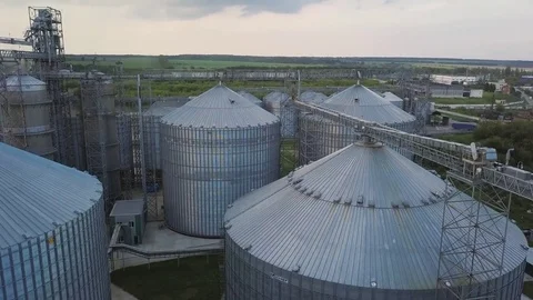 Flight under granaries and elevators or oil storage on sunset Stock Footage 78991524