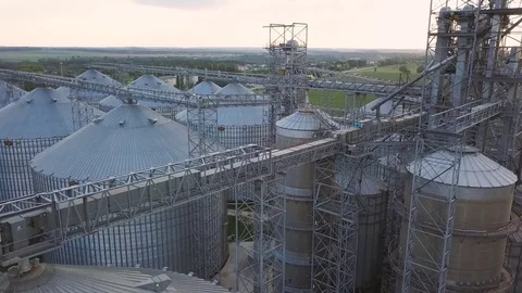 Flight under granaries and elevators or oil storage on sunset Stock Footage 78991557