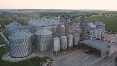Flight under granaries and elevators or oil storage on sunset Stock Footage 78991613