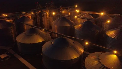Flight under granaries and elevators or oil storage at night Stock Footage 79834934