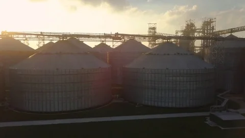Flight under granaries and elevators or oil storage on sunset Stock Footage 79834963