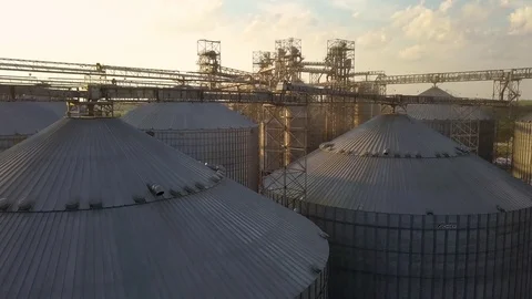 Flight under granaries and elevators or oil storage on sunset Stock Footage 79835004