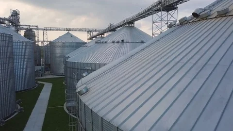 Flight under granaries and elevators or oil storage on sunset Stock Footage 79835038