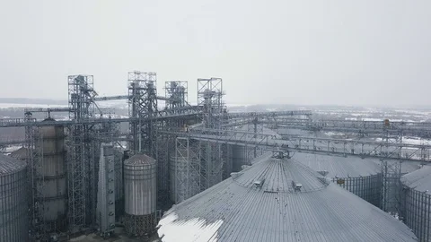 Flight under granaries and elevators or oil storage on winter background Stock Footage 88410668