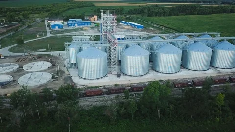 Flight under granaries and elevators or oil storage on sunset Stock Footage 92568624