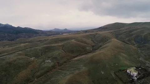 Flight on a valley with red hills and a house Stock Footage 86562299