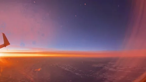 FLIGHT watching a stunning sunset above the clouds in airplane Stock Footage 153372077
