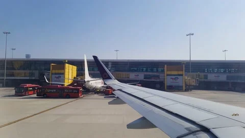 Flight window view aircraft leaving terminal for take off at day 스톡 동영상 203947173