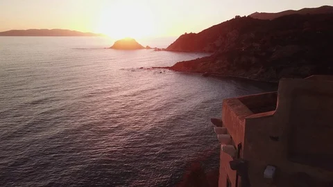 Fligt over the sea at sunset with a tower in foreground Stock Footage 106541544