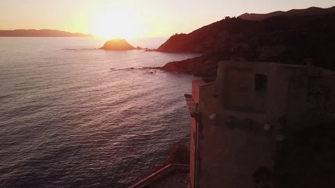 Fligt over the sea at sunset with a tower in foreground Stock Footage 106541863