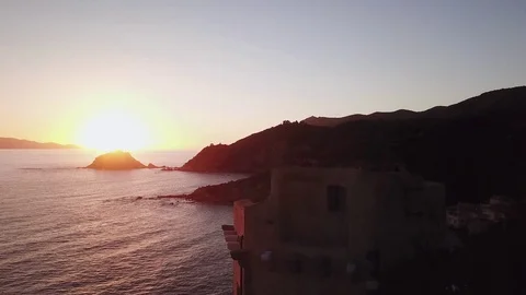 Fligt over the sea at sunset with a tower in foreground Stock Footage 106542096