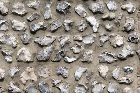 Flint wall background showing rough grey stones embedded in concrete Stock Photos