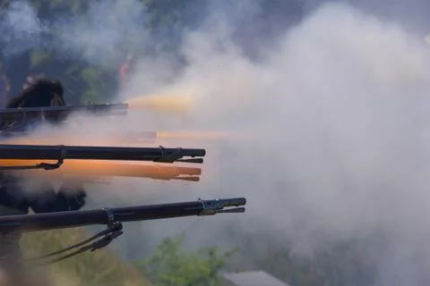 Flintlock muzzle loader muskets guns firing. Smoke from the gunpowder fills t Stock Photos