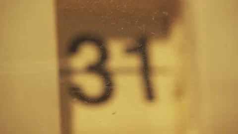 A flip clock changing date number behind an old plastic case Stock Footage 284806239
