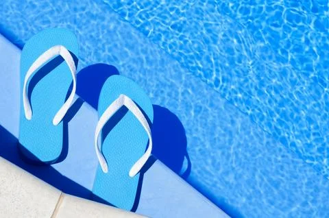 Flip flops on the background of the pool. Stock Photos