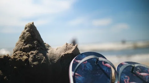 Flip Flops on the Beach. Behind two Men in the Ocean on Sunny day Stock-Footage 112896105