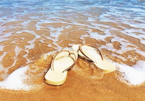 Flip flops on the beach in the ocean surf, Bang Kao, Phetchaburi, Thailand Stock Photos